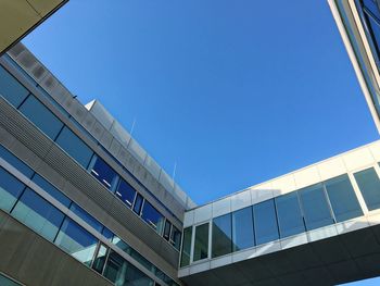 Low angle view of modern building against blue sky