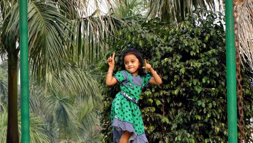 Girl dancing against trees at park