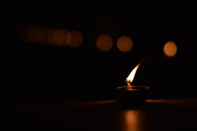 Close-up of tea light candle on table at night