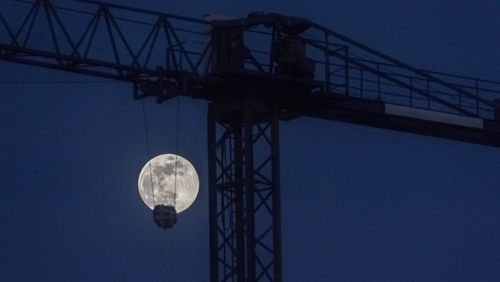 Low angle view of crane against sky at night