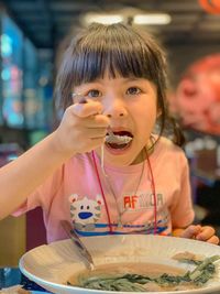 Portrait of a girl eating food in restaurant