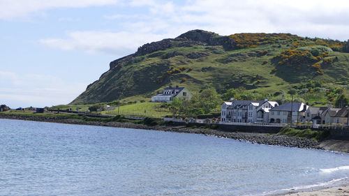 Scenic view of sea by buildings against sky