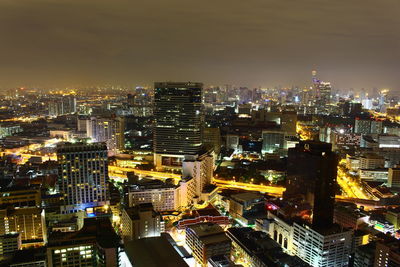 Illuminated cityscape against sky at night