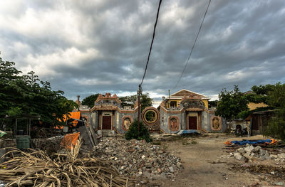 Abandoned building against cloudy sky