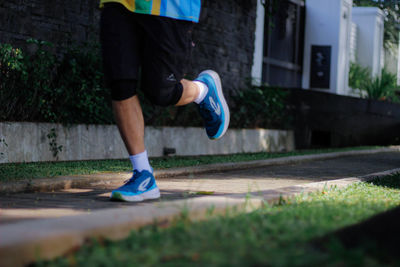 Low section of woman walking on footpath