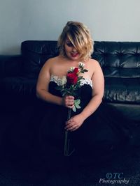 Portrait of a beautiful young woman sitting on wall