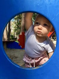 Toddler playing on the playground, portrait in the shape of a circle