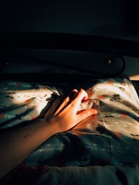 Close-up of woman hand on bed