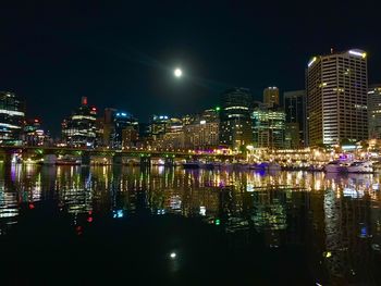 Illuminated modern buildings against sky at night