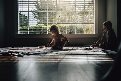 Woman sitting on window at home