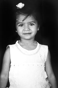 Portrait of smiling girl standing against wall