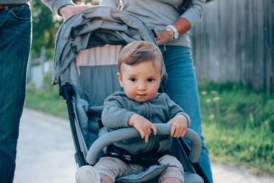 Midsection of parents with son on road