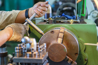 Cropped hands of worker operating equipment in workshop