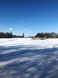 Snow covered road against blue sky