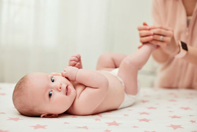 Close-up of cute baby lying on bed at home