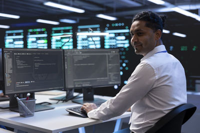 Side view of young man working in office