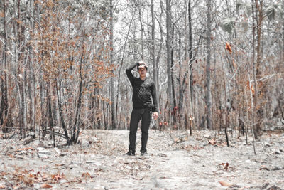 Full length portrait of man standing in forest