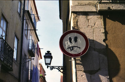 Anthropomorphic face on road sign against building