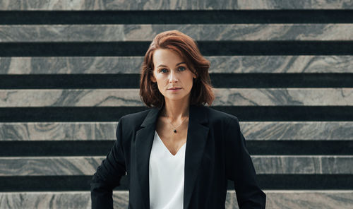 Young woman standing against corrugated iron