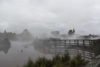 Misty river and wood bridge disappearing into the fog. beautiful geothermal landscape