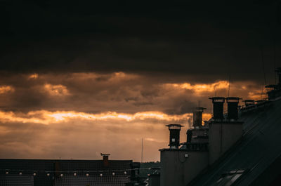 Storm clouds over buildings during sunset