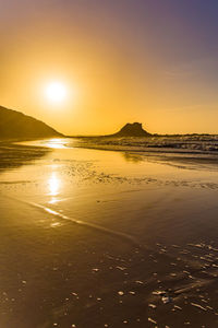 Scenic view of beach against sky during sunset