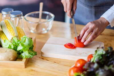 Midsection of man preparing food on cutting board