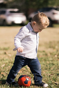 Little boy playing with soccer ball outdoors