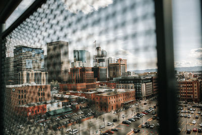 High angle view of buildings against sky seen through glass window