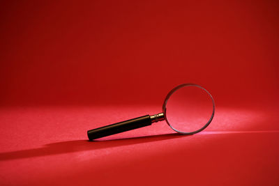 High angle view of eyeglasses on table against red background