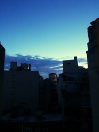 Silhouette buildings against sky at sunset