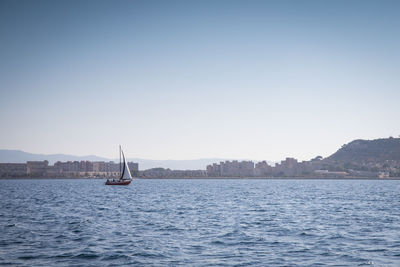Sailboat sailing on sea against clear sky