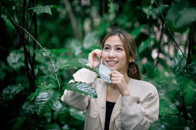 Portrait of smiling young woman holding plant