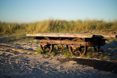 Scenic view of field by lake against clear sky