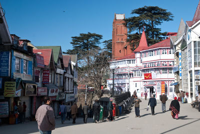 People walking on road along buildings