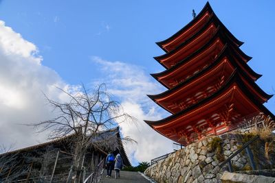 Low angle view of man amidst buildings against sky