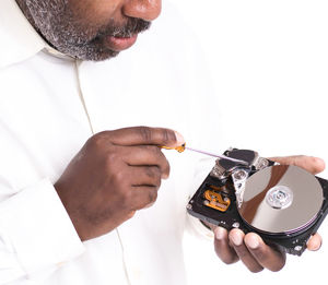 Midsection of man holding camera over white background