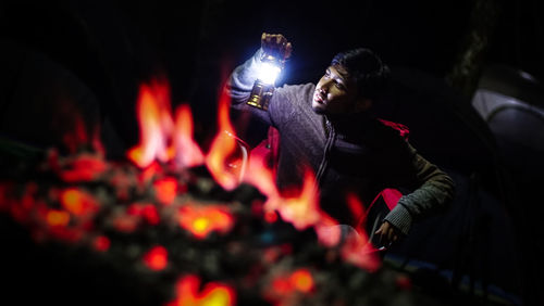 Reflection of people on illuminated fire at night