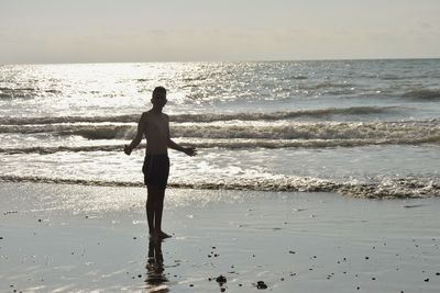 Full length of man standing on beach against sky