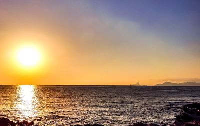 Scenic view of sea against orange sky