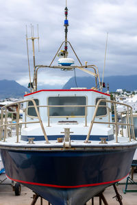 Ship moored at harbor against sky