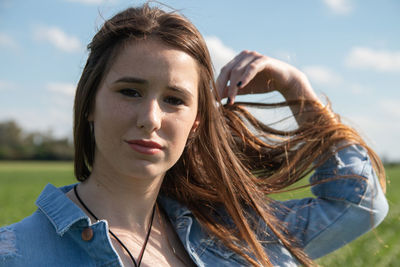 Portrait of young woman against sky