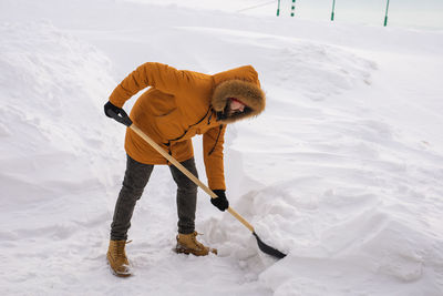 Low section of man skiing on snow covered field