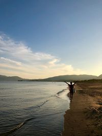 Man standing in sea against sky