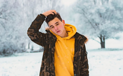 Portrait of young man in snowy winter forest. season, christmas