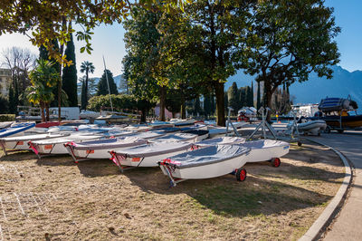 Boats moored on road by trees in city