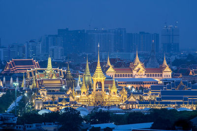Illuminated buildings in city at dusk