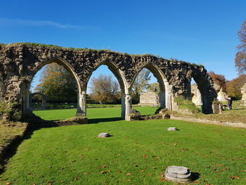 Arched structure on field against clear sky