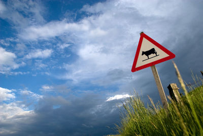 Low angle view of road sign against sky