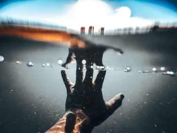 Close-up of hands against water